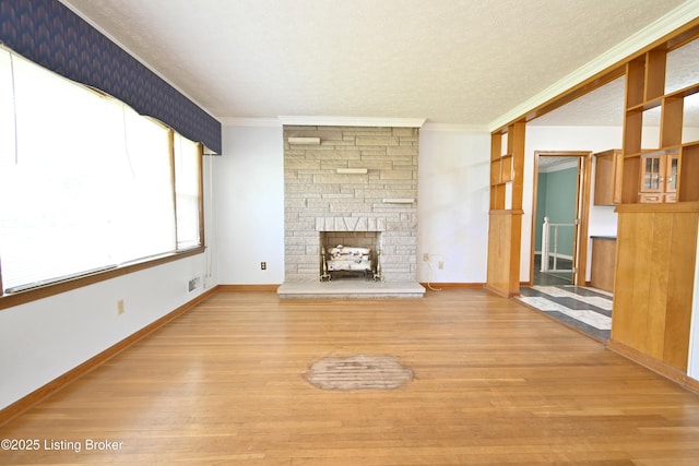 unfurnished living room featuring crown molding, wood finished floors, visible vents, and a fireplace