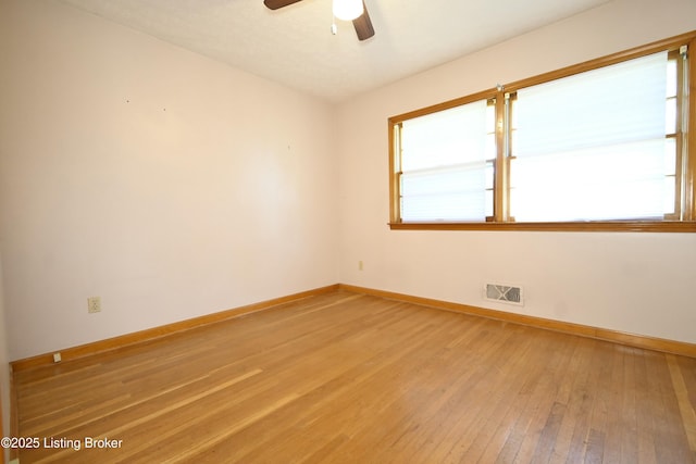 unfurnished room with light wood-style floors, baseboards, ceiling fan, and visible vents