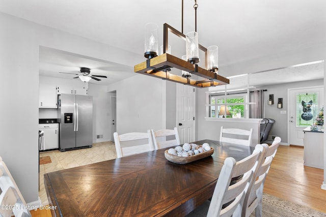 dining area with baseboards, a wealth of natural light, visible vents, and ceiling fan with notable chandelier
