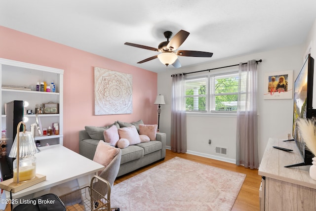 office featuring light wood-type flooring, baseboards, visible vents, and ceiling fan
