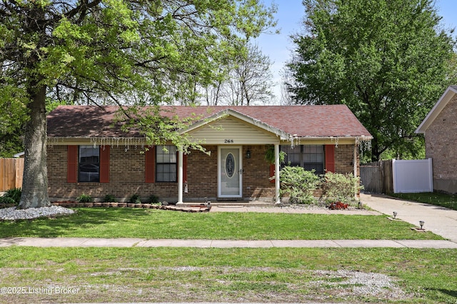ranch-style house with a front lawn, brick siding, and fence
