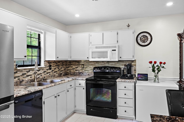 kitchen with black appliances, backsplash, a sink, and light countertops