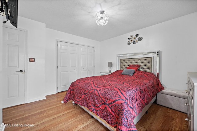 bedroom featuring baseboards, wood finished floors, and a closet