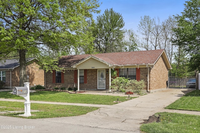ranch-style home with brick siding, a front yard, concrete driveway, and fence