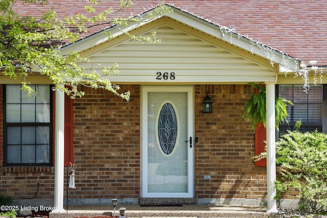 view of exterior entry featuring brick siding