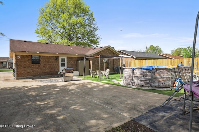 back of house with brick siding, a patio area, and a fenced backyard