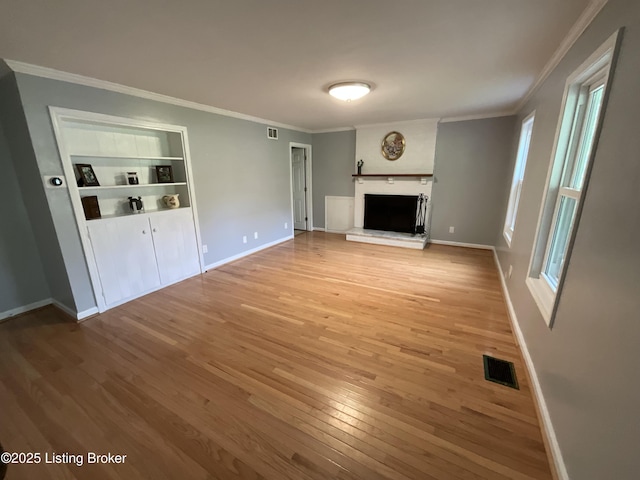 224 Spring Creek Ln, Milton, KY 40045 - unfurnished living room featuring visible vents, light wood-style floors, crown molding, baseboards, and a fireplace