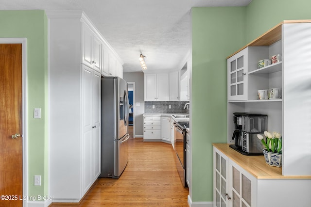 2807 Alice Ave, Louisville, KY 40220 - kitchen with appliances with stainless steel finishes, white cabinets, light wood-style flooring, decorative backsplash, and light countertops