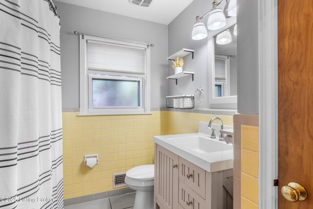 2807 Alice Ave, Louisville, KY 40220 - bathroom featuring tile patterned flooring, toilet, tile walls, a wainscoted wall, and vanity