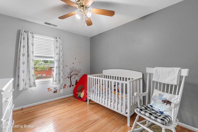2807 Alice Ave, Louisville, KY 40220 - bedroom with hardwood / wood-style flooring, a ceiling fan, a nursery area, and baseboards