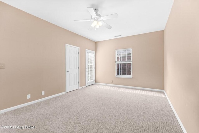 empty room with baseboards, a ceiling fan, visible vents, and carpet