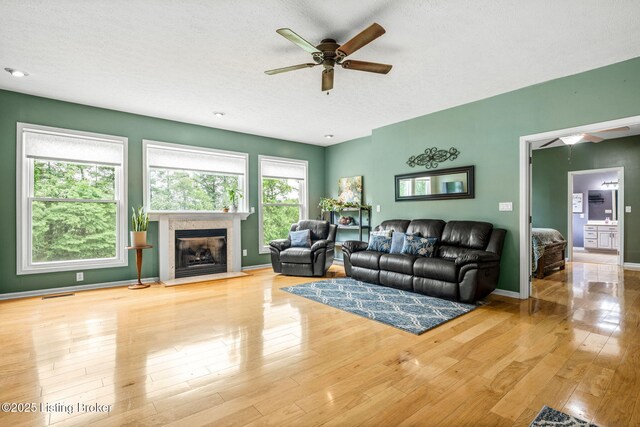 5502 Highpoint Dr, Crestwood, KY 40014 - living area featuring a ceiling fan, a glass covered fireplace, wood finished floors, and a textured ceiling