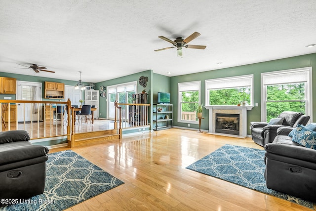 5502 Highpoint Dr, Crestwood, KY 40014 - living area with a ceiling fan, a textured ceiling, a fireplace with flush hearth, and wood finished floors