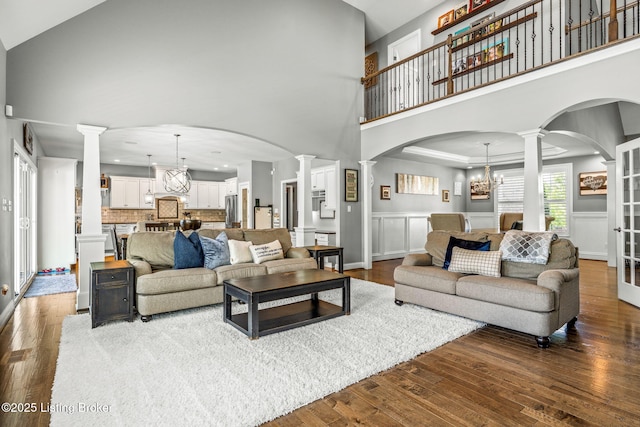 10905 Rock Valley Ct, Louisville, KY 40241 - living area featuring decorative columns, dark wood-style floors, a towering ceiling, and a decorative wall