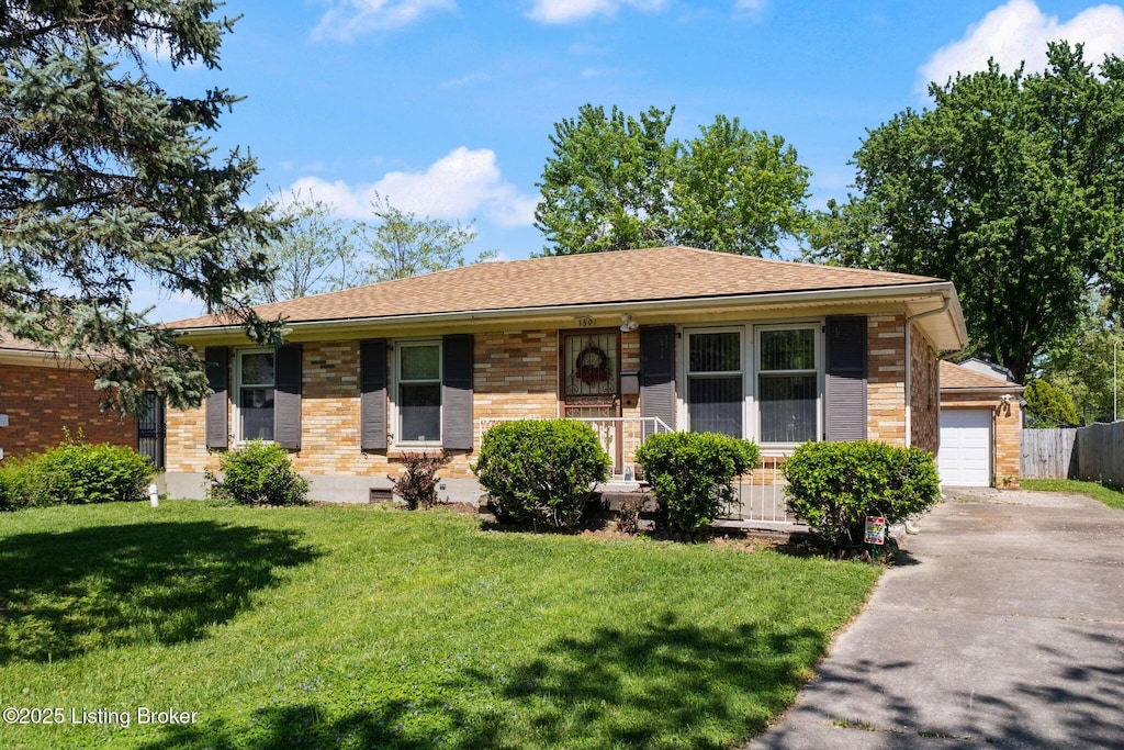 single story home with fence, a front lawn, concrete driveway, and brick siding
