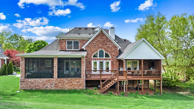 back of property with brick siding, a sunroom, and a lawn