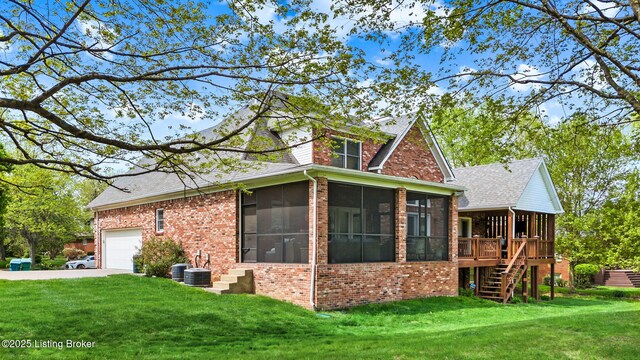 exterior space with brick siding, a yard, and a sunroom