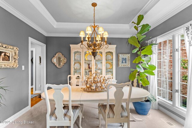 dining space featuring carpet flooring, a wealth of natural light, a chandelier, and a tray ceiling