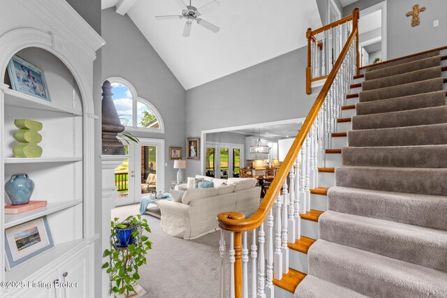 stairway with high vaulted ceiling, a ceiling fan, french doors, and beam ceiling