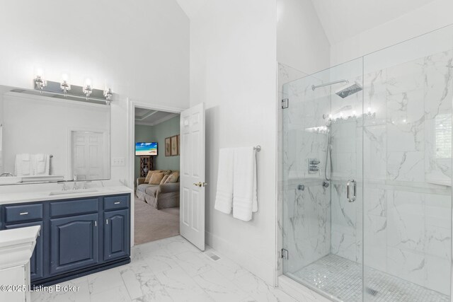 bathroom featuring high vaulted ceiling, a marble finish shower, vanity, marble finish floor, and baseboards