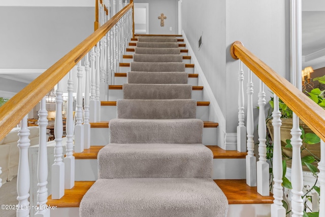 stairs featuring crown molding and visible vents