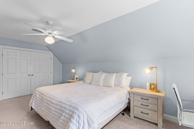 bedroom featuring vaulted ceiling, a closet, carpet flooring, and a ceiling fan