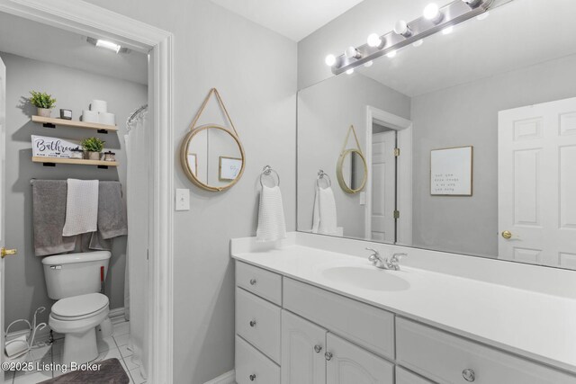 bathroom with baseboards, toilet, and vanity