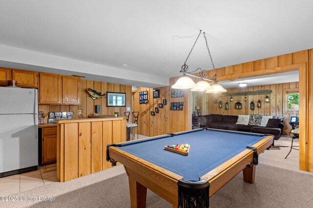 game room with wood walls, pool table, and plenty of natural light