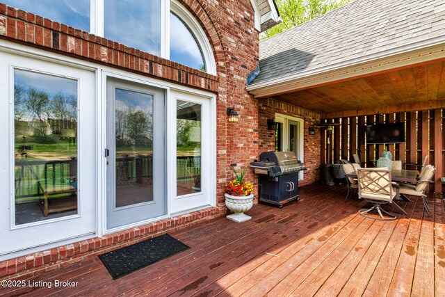 wooden deck with outdoor dining space and a grill