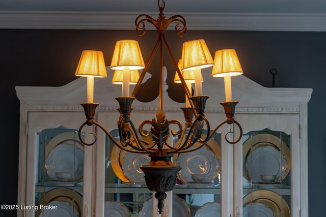 interior details with ornamental molding and an inviting chandelier