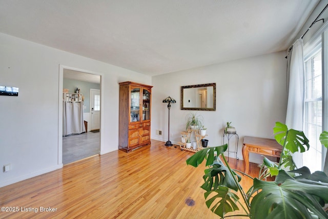 sitting room with baseboards and light wood-style floors
