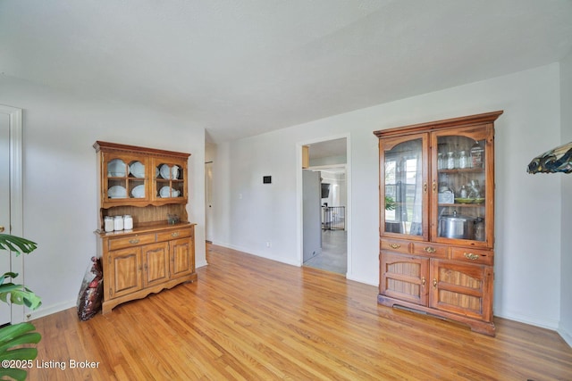 interior space featuring light wood-style flooring and baseboards