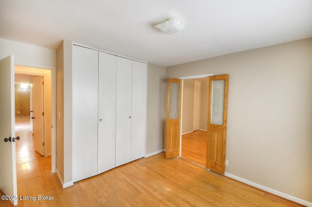 6706 Hollow Tree Rd, Louisville, KY 40228 - unfurnished bedroom featuring a closet, light wood-type flooring, and baseboards
