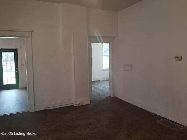 210 E Ormsby Ave, Louisville, KY 40203 - unfurnished room with baseboards, dark colored carpet, visible vents, and plenty of natural light