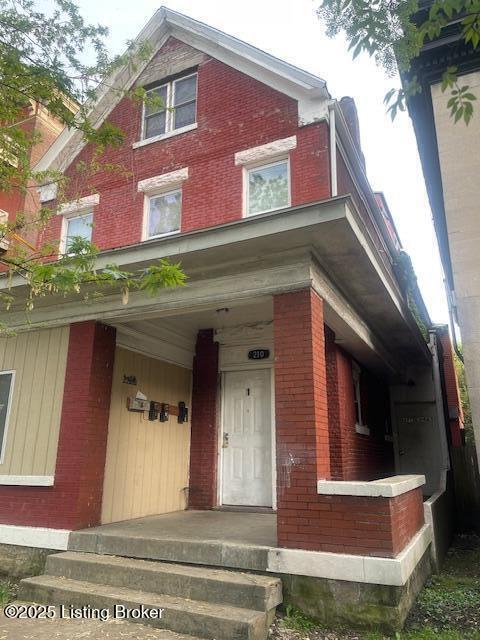 210 E Ormsby Ave, Louisville, KY 40203 - view of front facade featuring brick siding and a porch