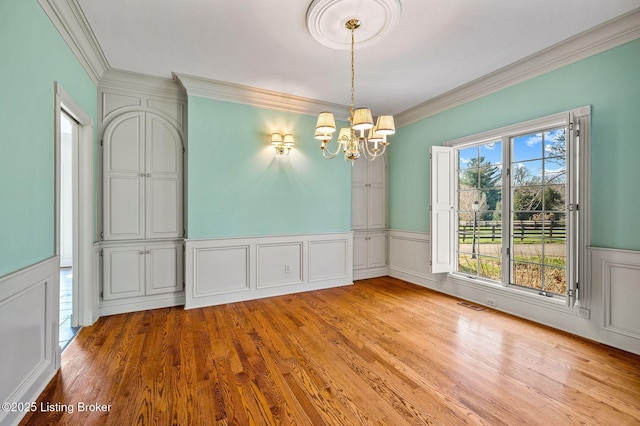 2605 Evergreen Wynde, Louisville, KY 40223 - unfurnished dining area with an inviting chandelier, wood finished floors, crown molding, and wainscoting