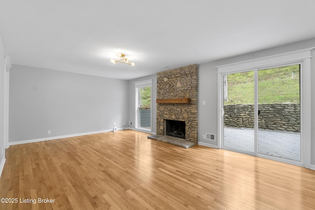 unfurnished living room featuring light wood-type flooring, baseboards, visible vents, and a fireplace