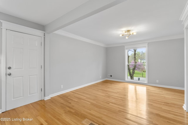 empty room with light wood-type flooring, visible vents, baseboards, and ornamental molding