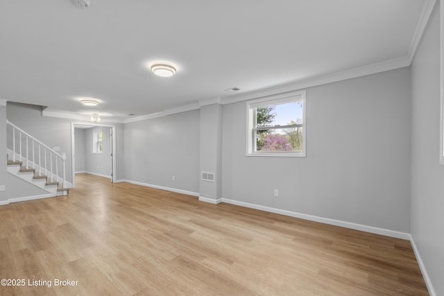 below grade area featuring stairway, light wood-type flooring, baseboards, ornamental molding, and visible vents