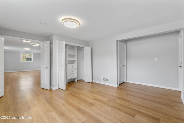 unfurnished bedroom with baseboards, light wood-style floors, and visible vents