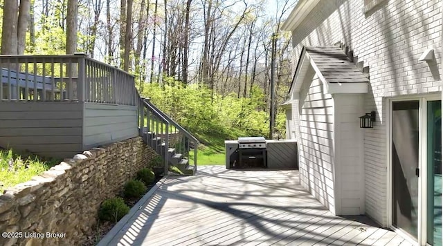wooden terrace featuring stairs and a grill