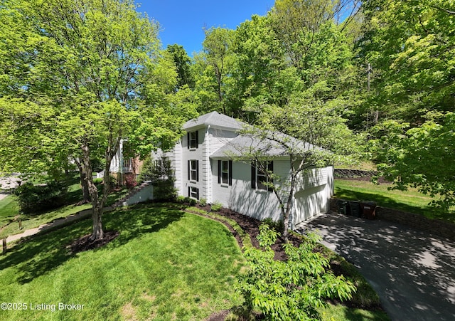 view of property exterior featuring a garage, driveway, and a yard