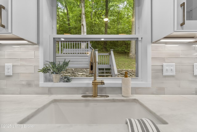 1907 Charbdin Pl, Louisville, KY 40207 - kitchen view of a sink, tasteful backsplash, and light stone countertops