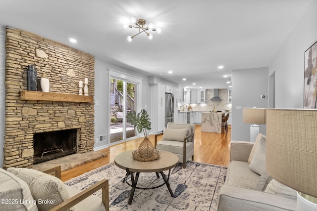 1907 Charbdin Pl, Louisville, KY 40207 - living area featuring light wood-type flooring, recessed lighting, a stone fireplace, and baseboards