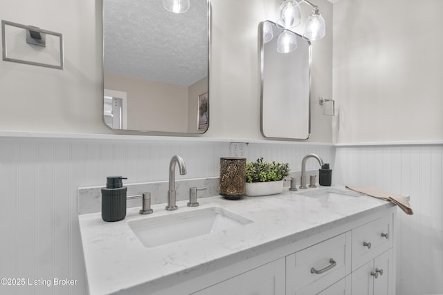1907 Charbdin Pl, Louisville, KY 40207 - bathroom with a textured ceiling, double vanity, and a wainscoted wall