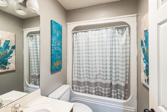 bathroom with shower / tub combo, toilet, a textured ceiling, and vanity