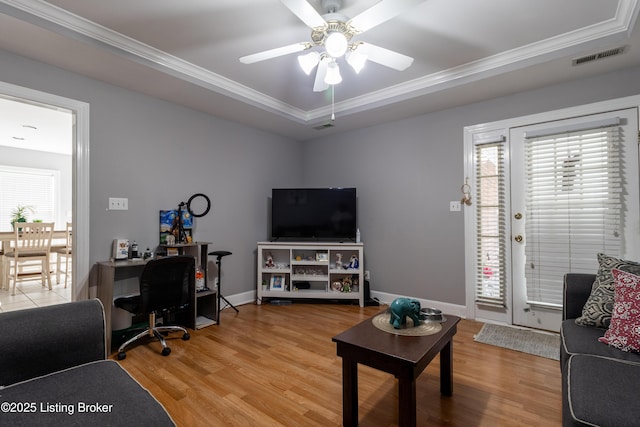 living area with ornamental molding, light wood-style flooring, and a wealth of natural light