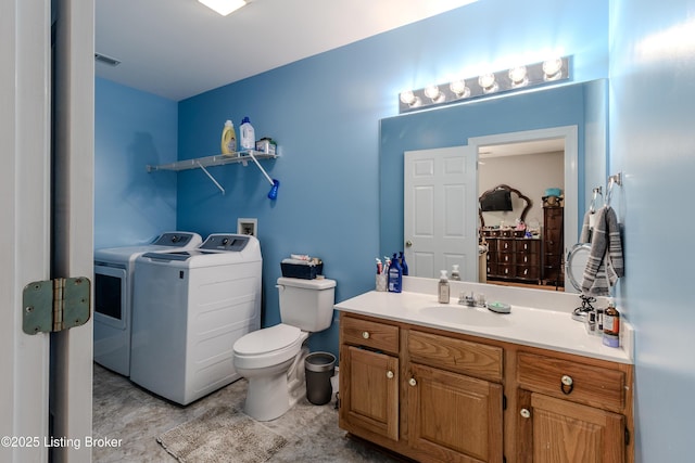 bathroom featuring independent washer and dryer, toilet, and vanity