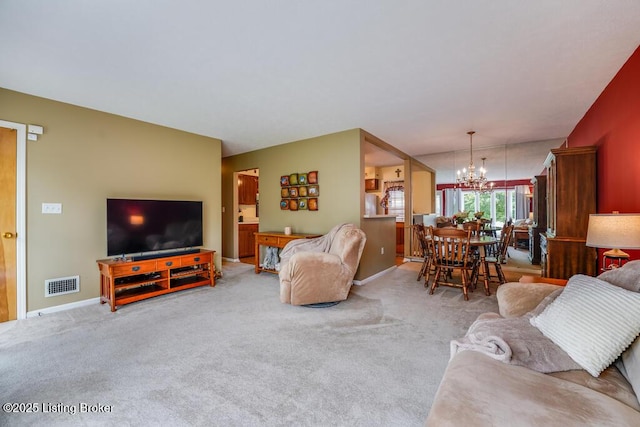 living room featuring baseboards, a notable chandelier, light colored carpet, and visible vents