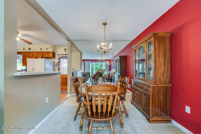 dining area featuring baseboards, ceiling fan with notable chandelier, and light colored carpet